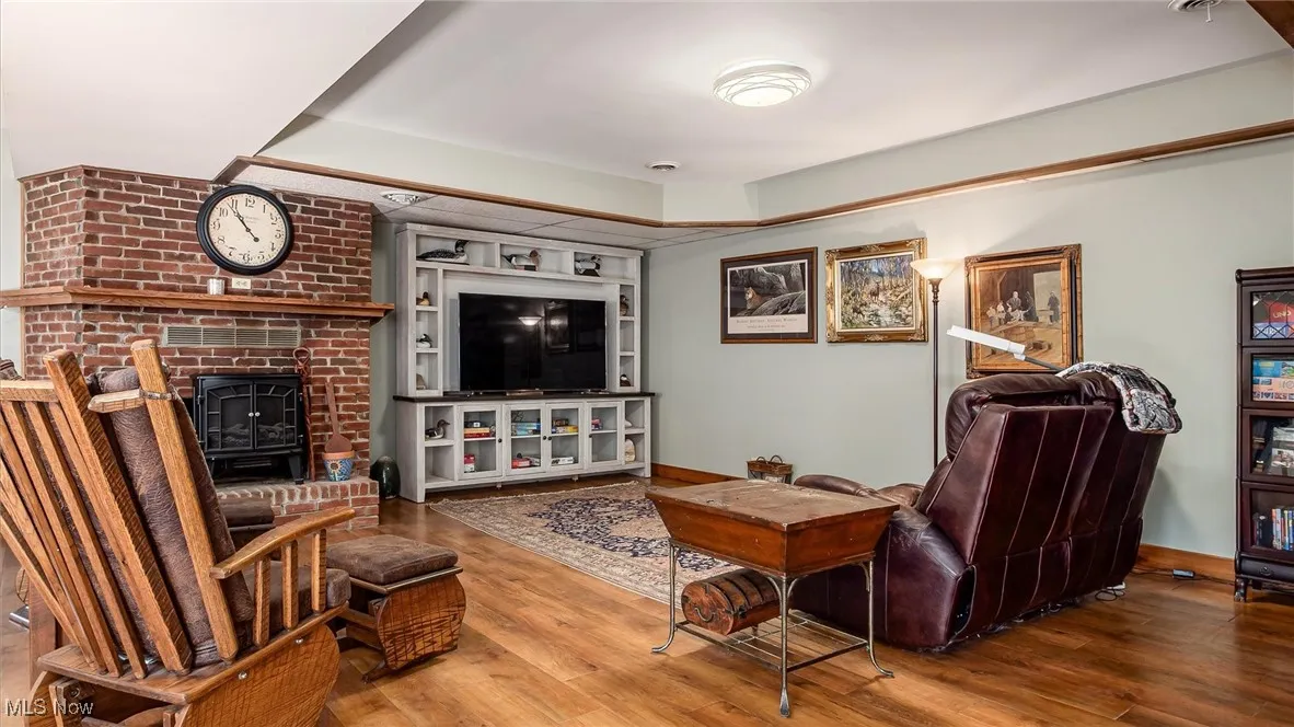 Living area featuring wood finished floors and a brick fireplace