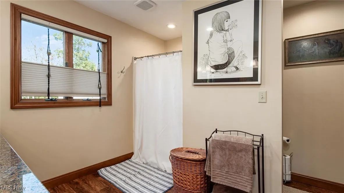 Full bathroom with a stall shower and dark wood finished floors