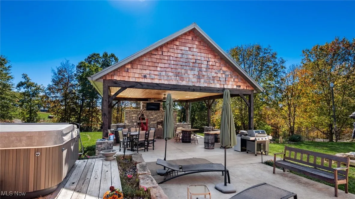 View of home's community featuring outdoor dining space, a patio, and a hot tub
