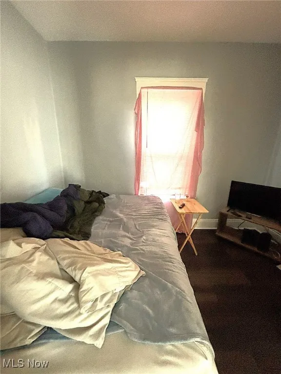 Bedroom with wood finished floors and baseboards
