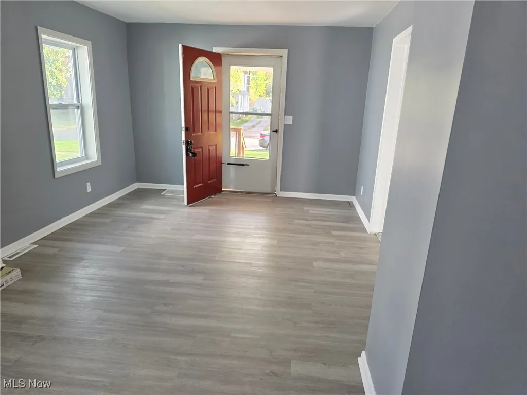 Entrance foyer with baseboards and light wood-style flooring