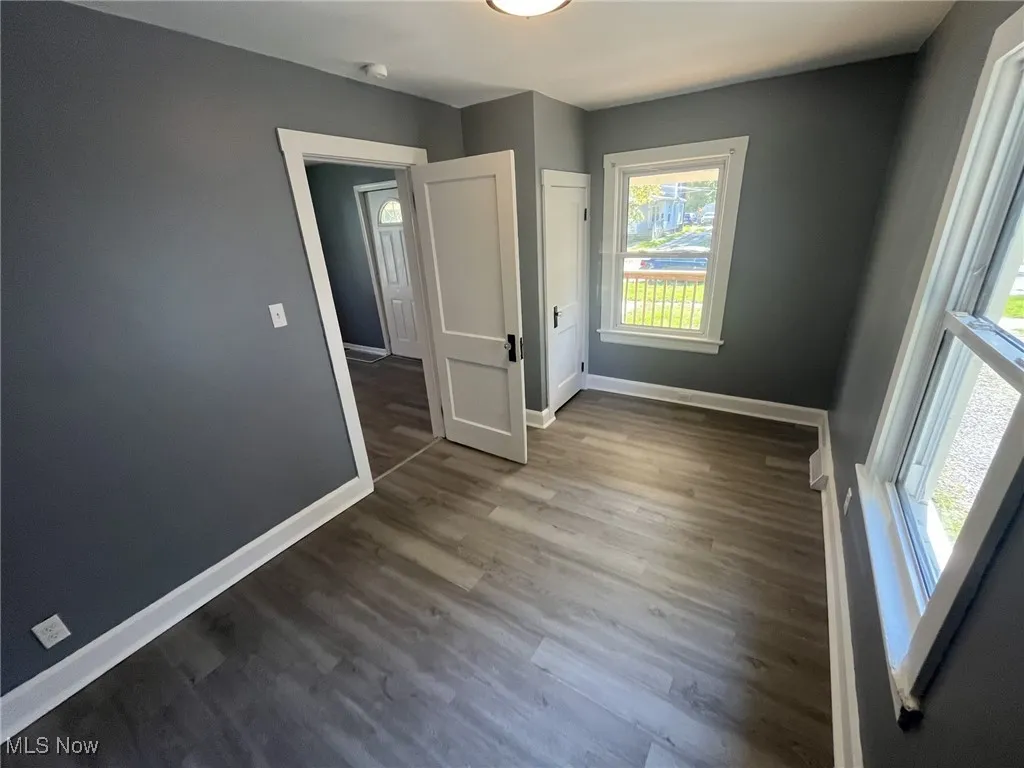 Unfurnished bedroom with baseboards and wood finished floors