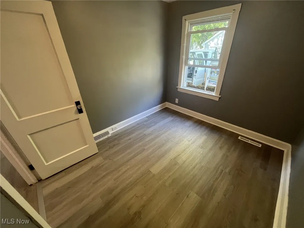 Spare room with wood finished floors and baseboards