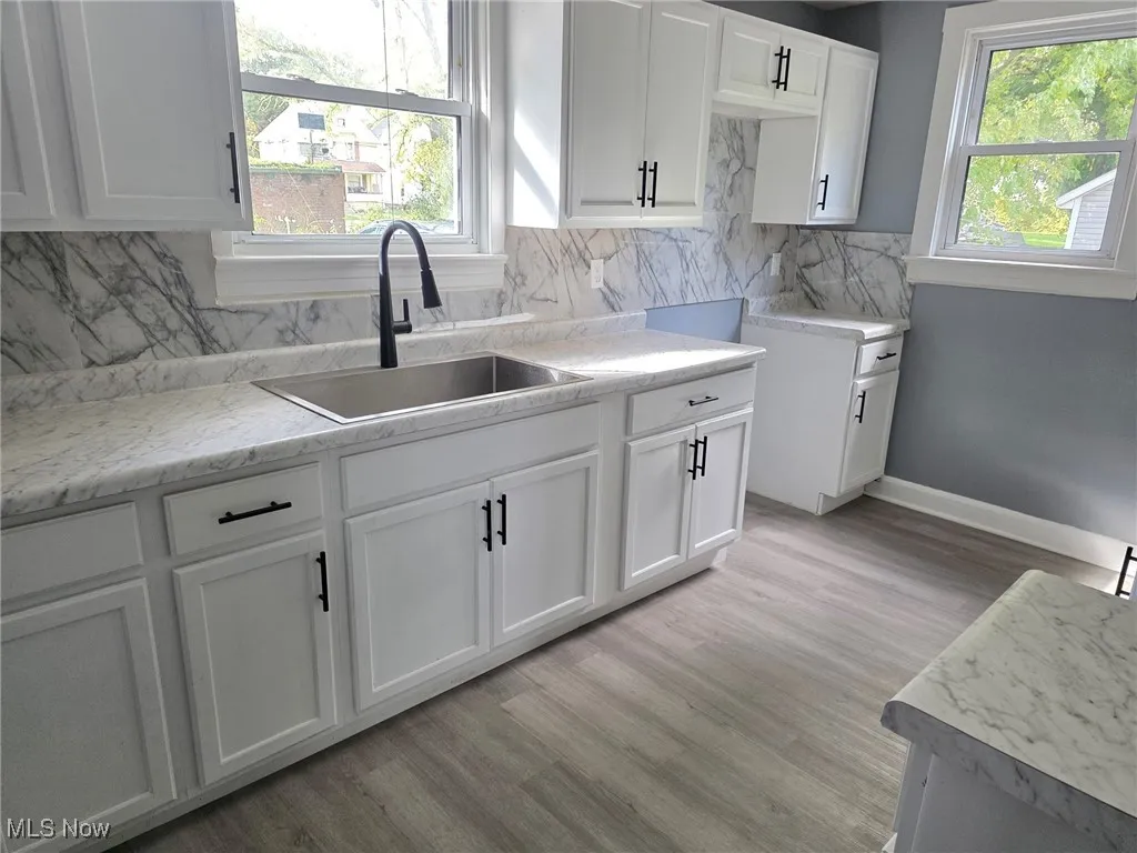 Kitchen featuring light countertops, white cabinets, and light wood-type flooring