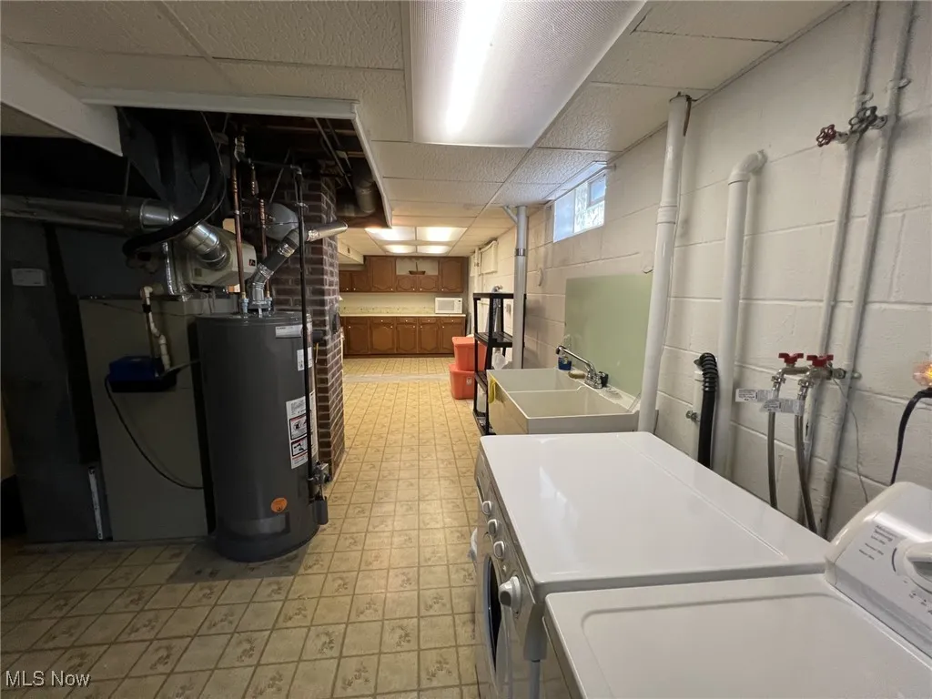 Laundry room with light floors, gas water heater, hookup for a washing machine, a paneled ceiling, and heating unit