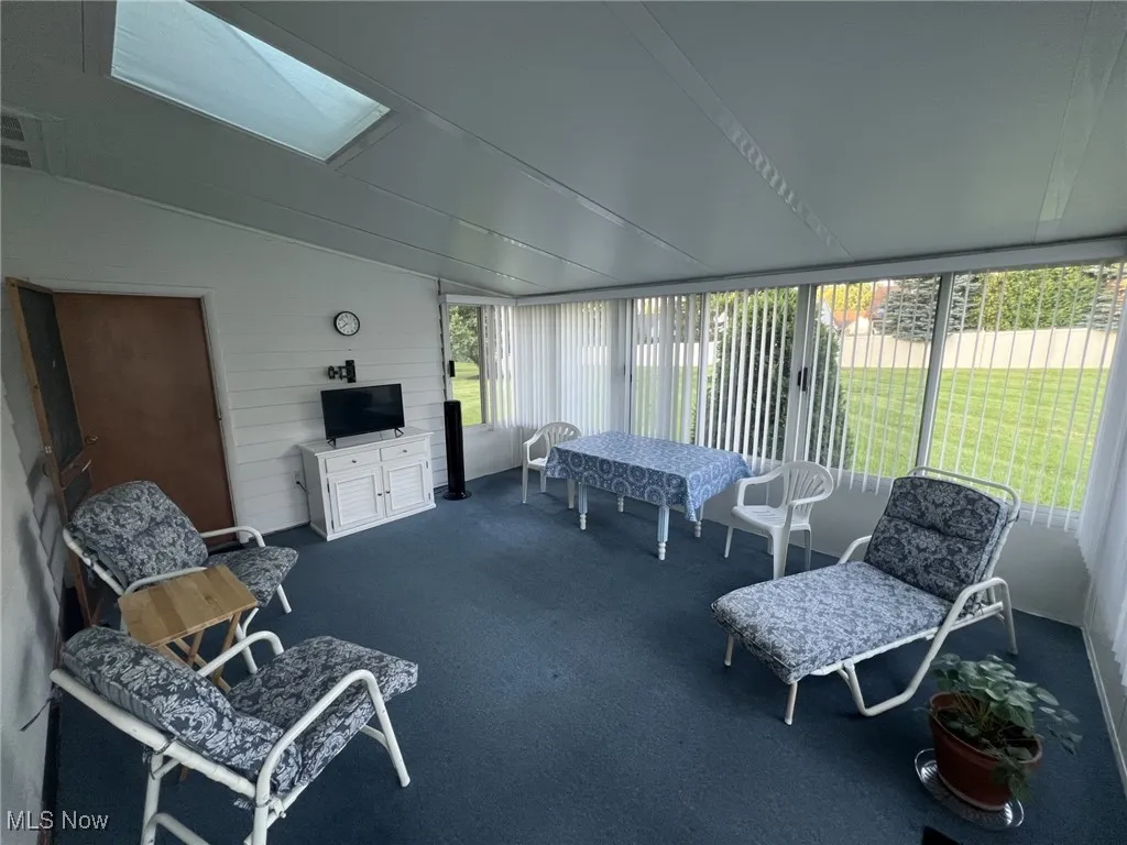 Sunroom featuring a skylight and vaulted ceiling