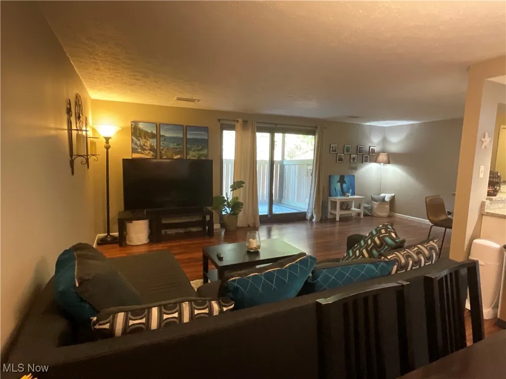 Living room with wood finished floors and a textured ceiling