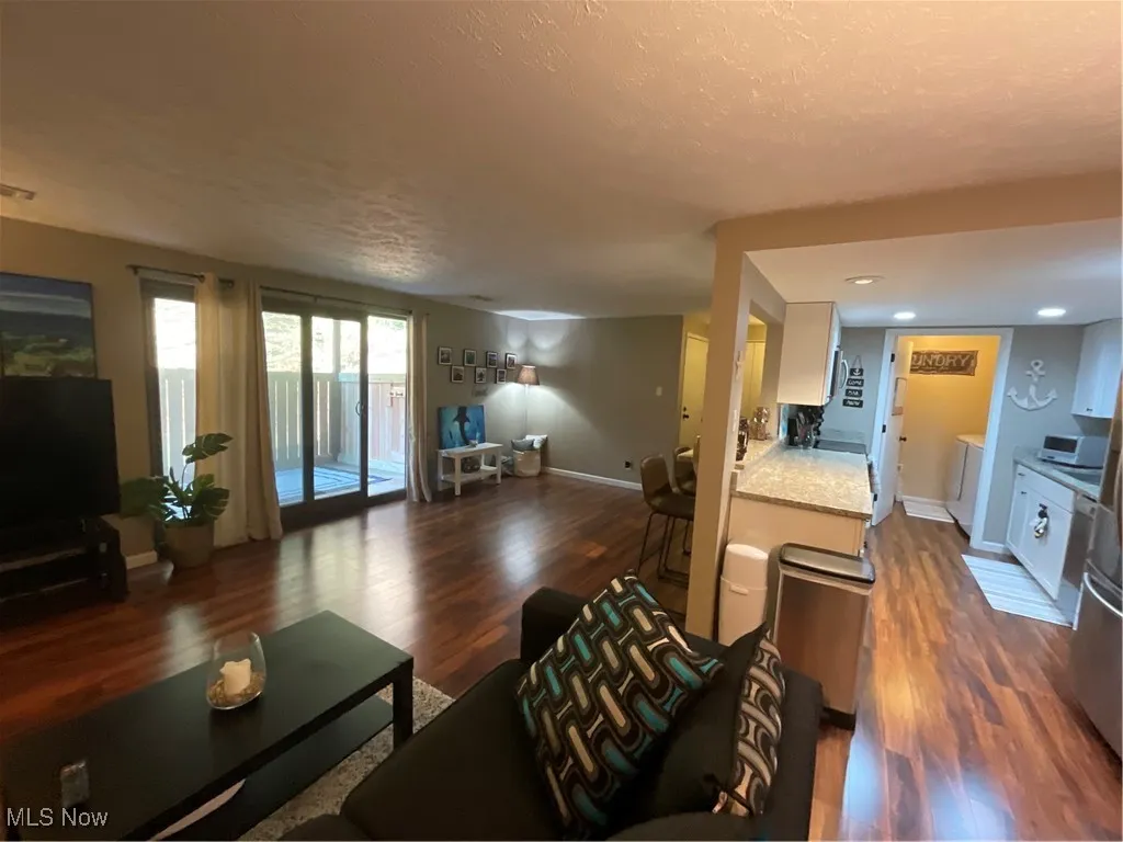 Living room with dark wood-type flooring and a textured ceiling