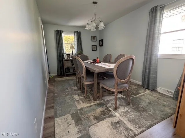 Dining space featuring wood finished floors and a chandelier