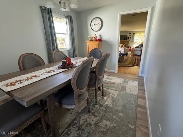 Dining area with wood finished floors and a chandelier