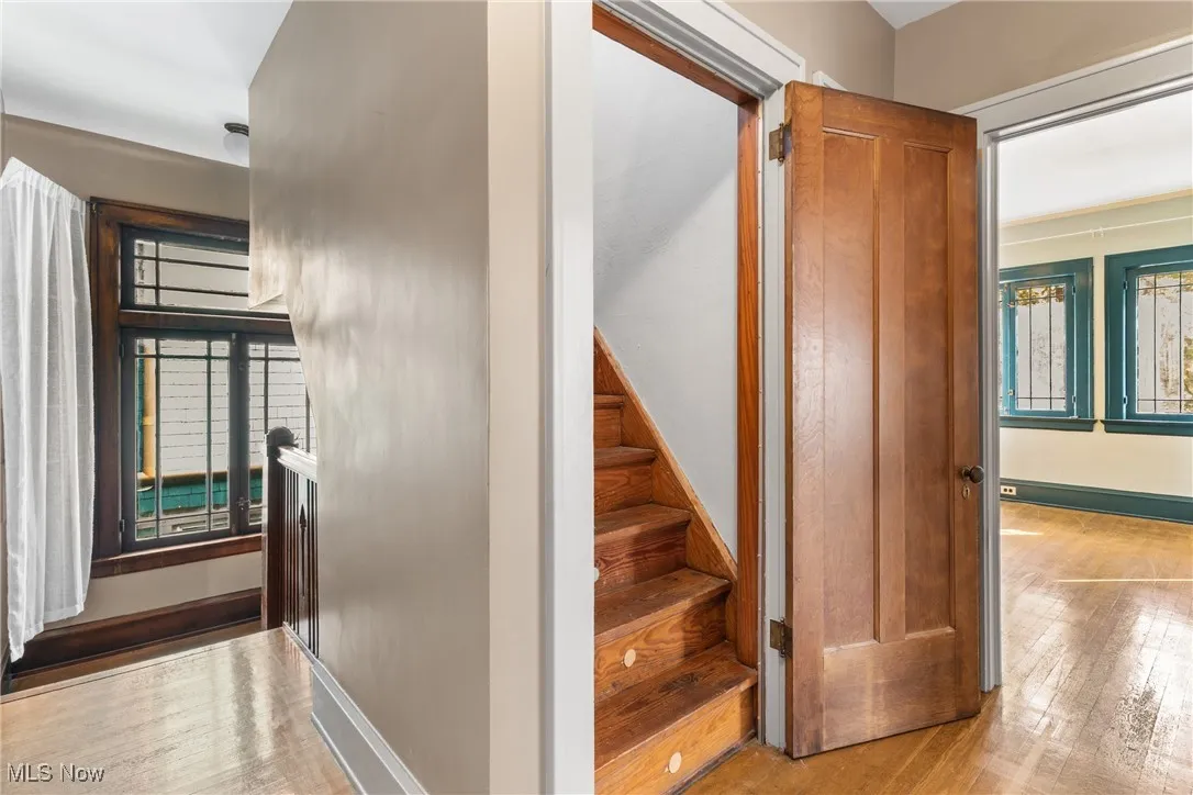 Stairs with hardwood / wood-style floors and baseboards