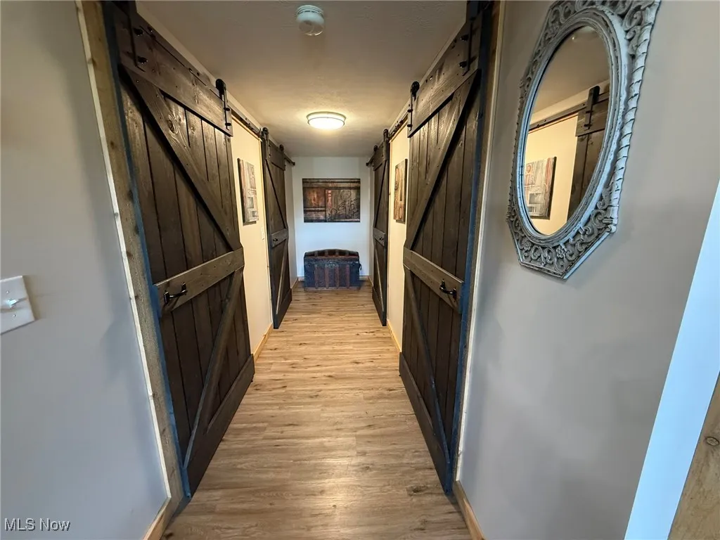 Corridor with baseboards and light wood-type flooring