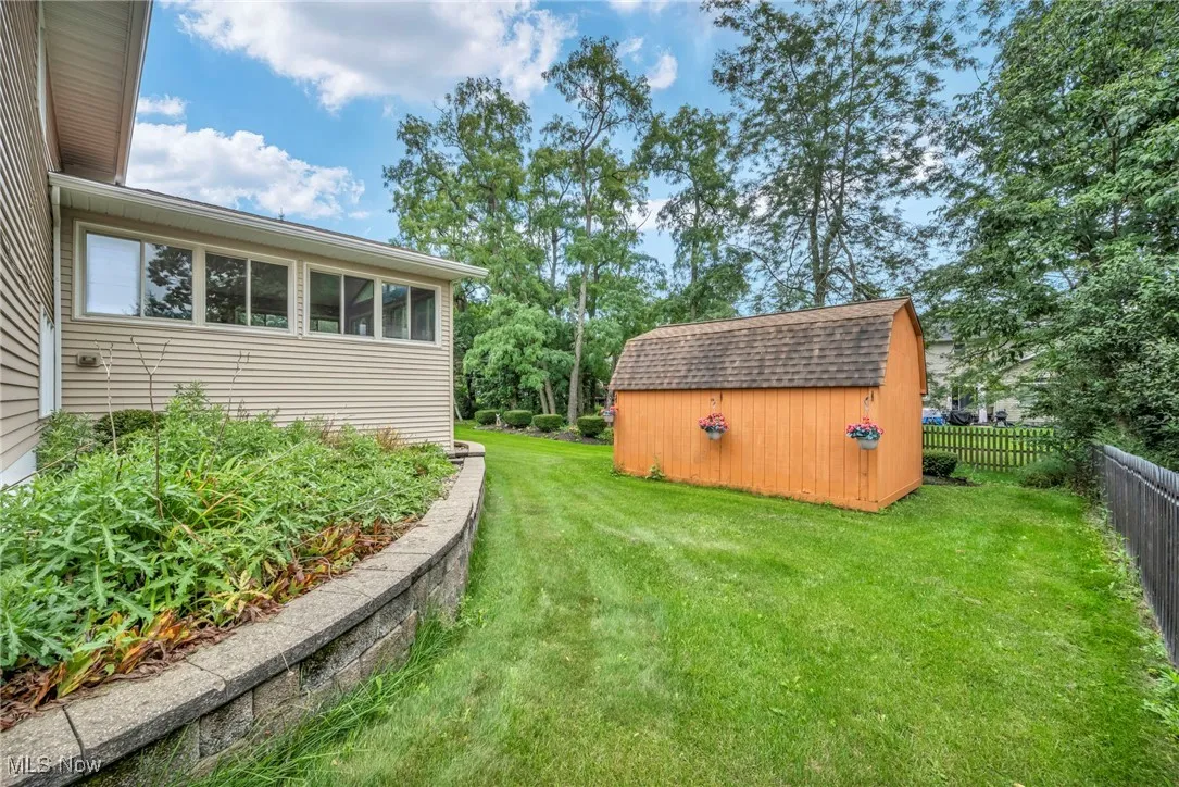 View of yard with a storage shed and a sunroom