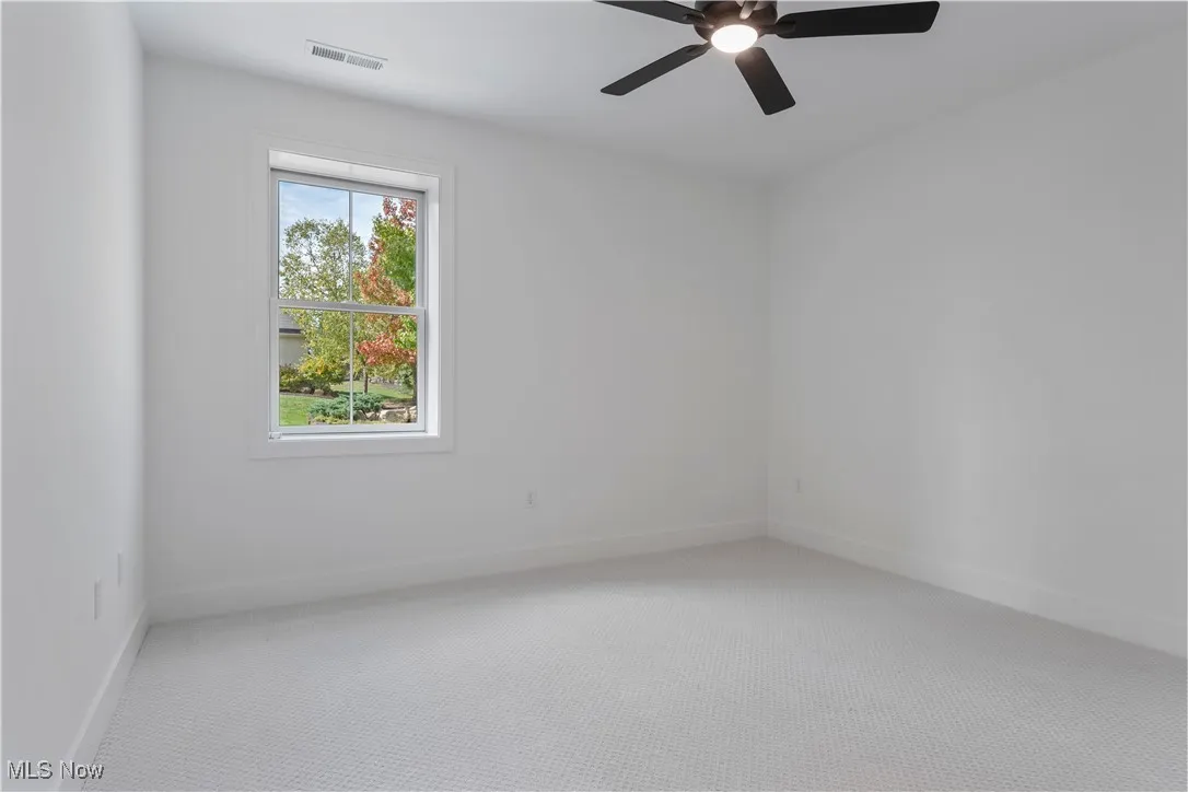 Unfurnished room with carpet and a ceiling fan
