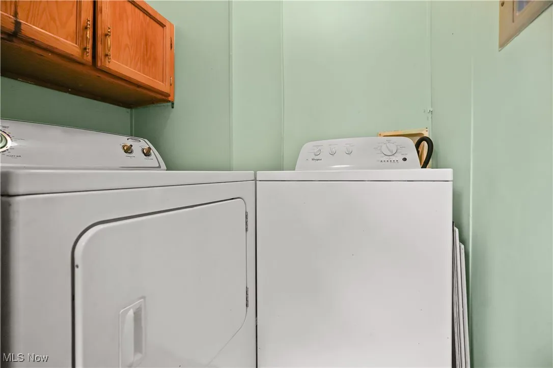 Laundry room featuring separate washer and dryer and cabinet space