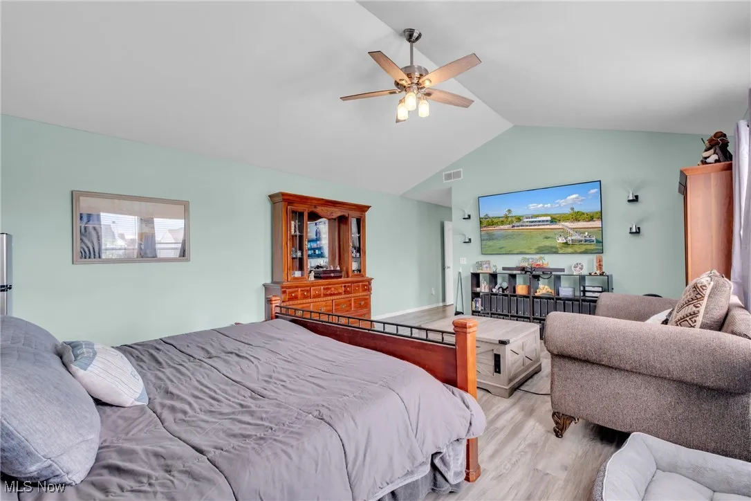 Bedroom featuring vaulted ceiling, wood finished floors, and a ceiling fan