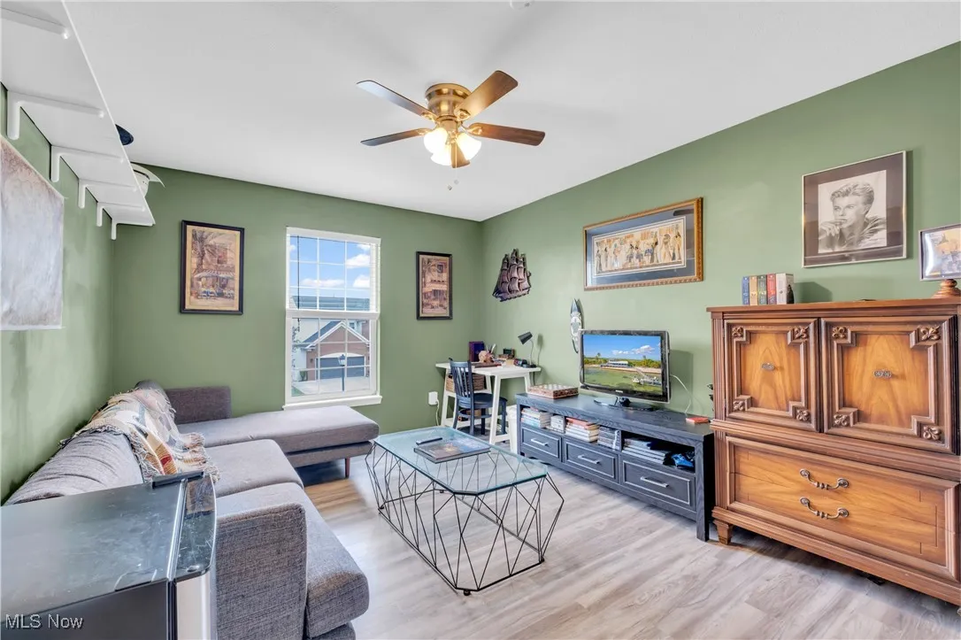 Living area with light wood finished floors and ceiling fan