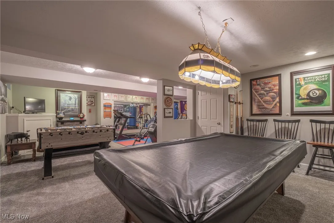 Playroom with carpet, billiards, and a textured ceiling