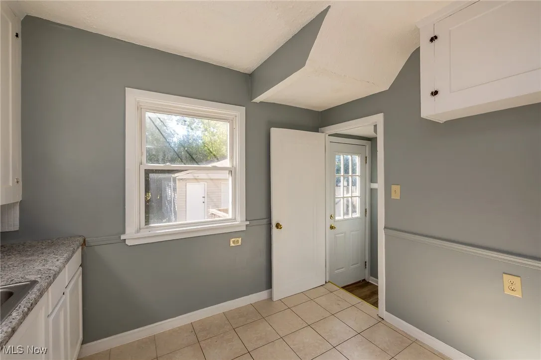 Entryway with tile patterned floors and baseboards