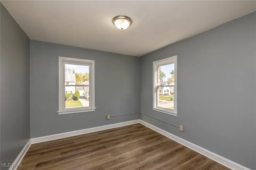 bedroom with dark wood-type flooring and baseboards