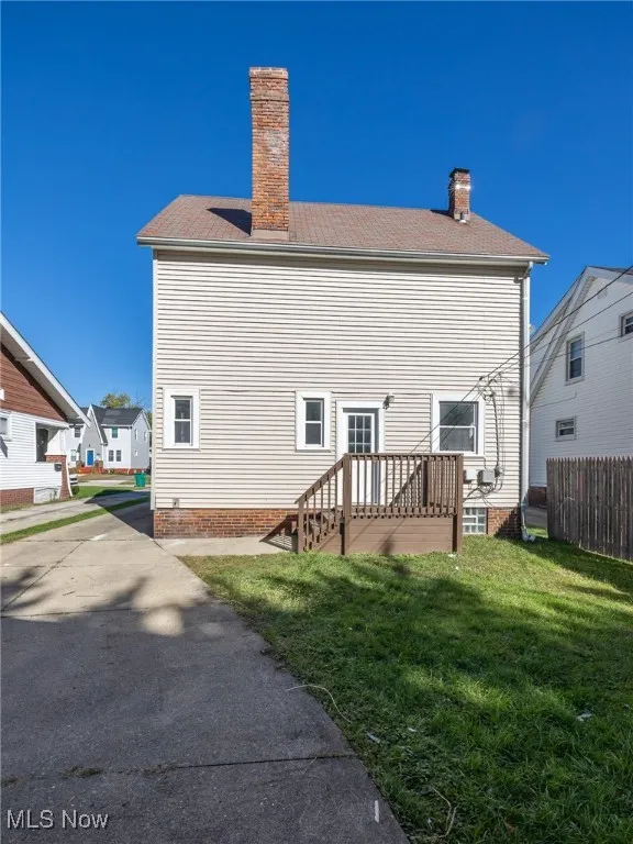 Rear view of house featuring a chimney and a wooden deck