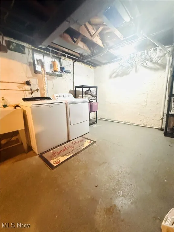 Unfinished basement featuring washer and clothes dryer and a sink