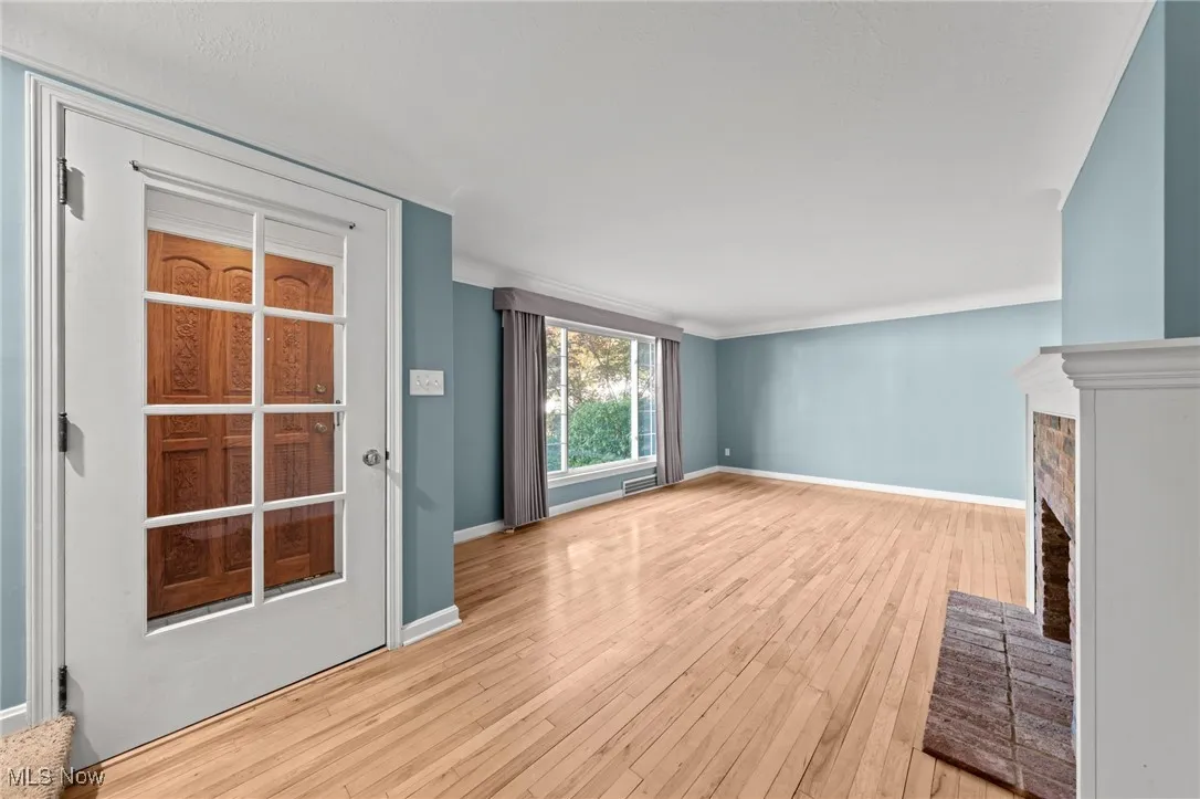 Unfurnished living room with light wood-style flooring and a brick fireplace