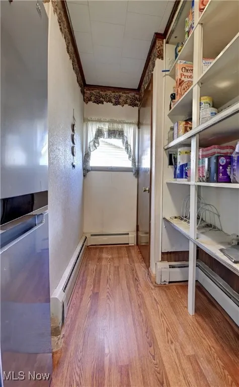 Storage room featuring a baseboard radiator and a baseboard heating unit