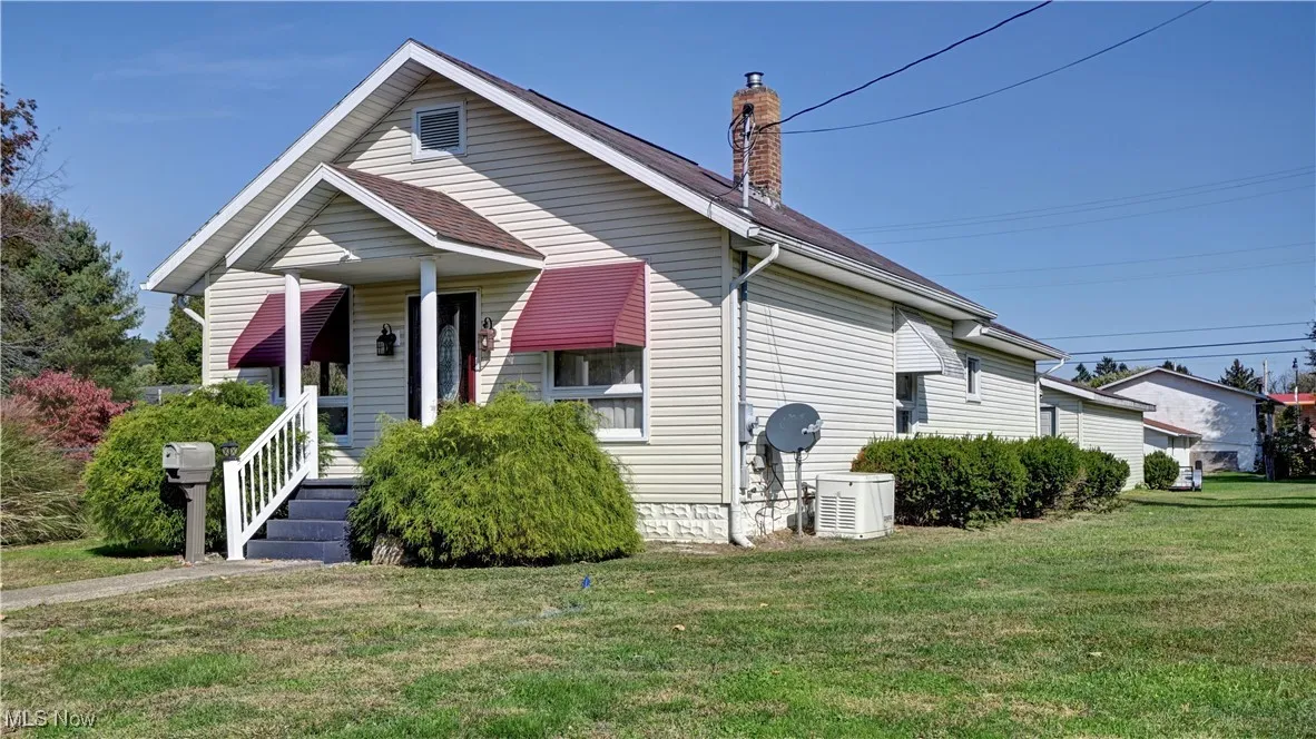 Bungalow-style home with a front lawn and a chimney