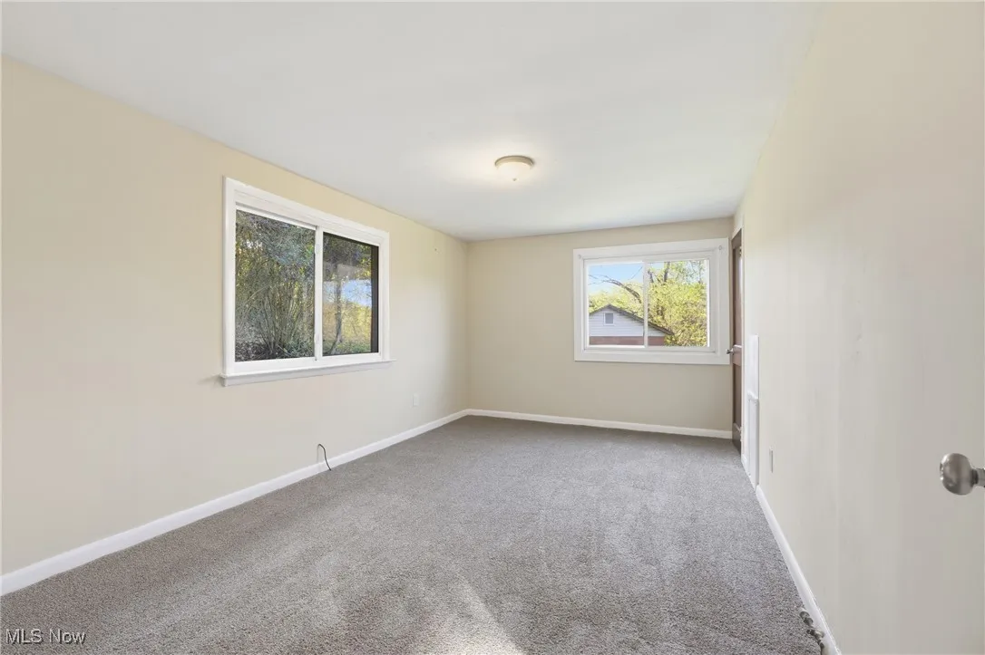 Spare room featuring carpet floors and baseboards