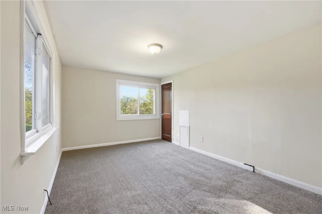 Spare room featuring carpet floors and baseboards
