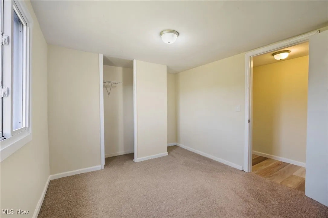 Unfurnished bedroom with light carpet and a closet