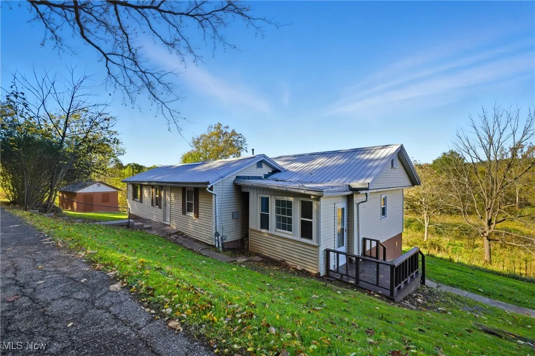 View of front facade with a front yard and a metal roof