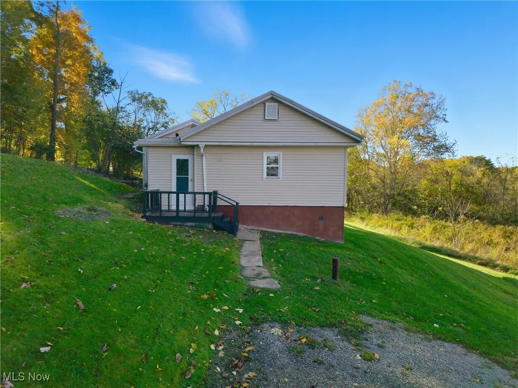 View of side of property with a lawn