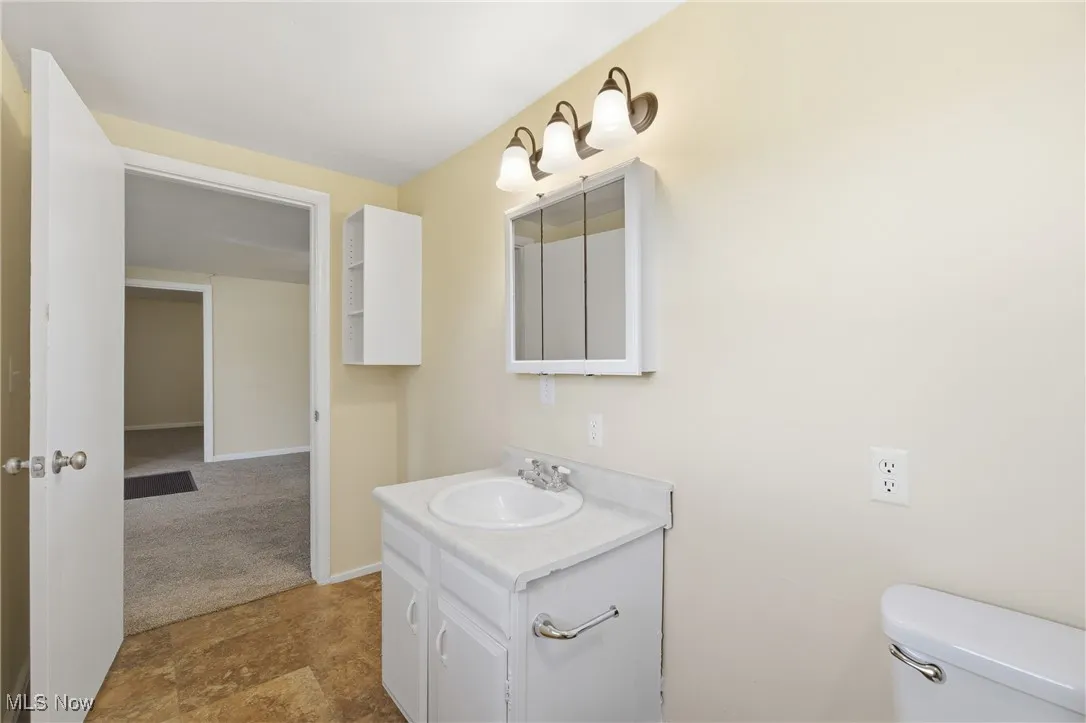 Half bath with vanity and stone finish flooring