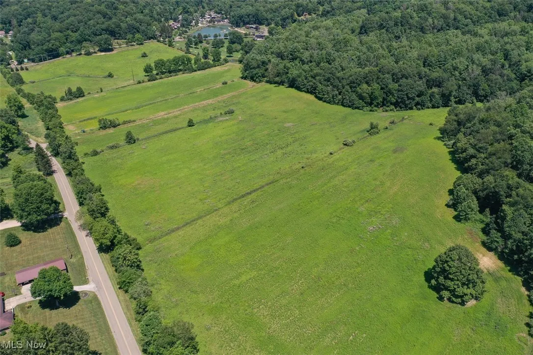 Aerial view of property and surrounding area featuring a forest
