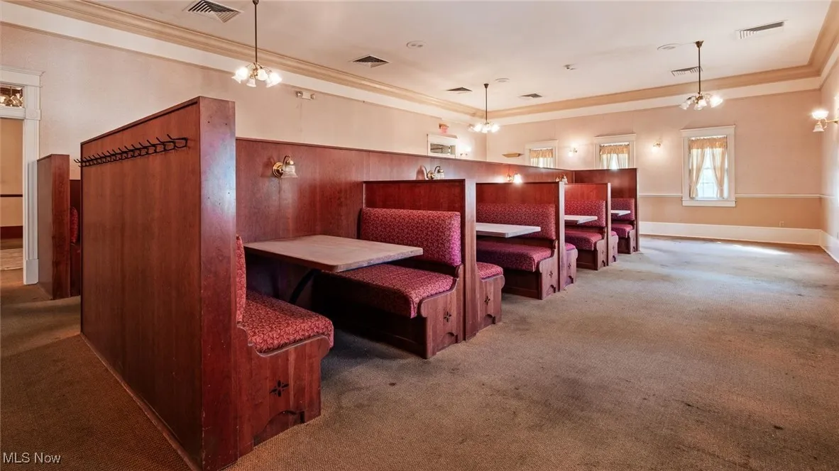 Home theater featuring ornamental molding, light carpet, and a chandelier