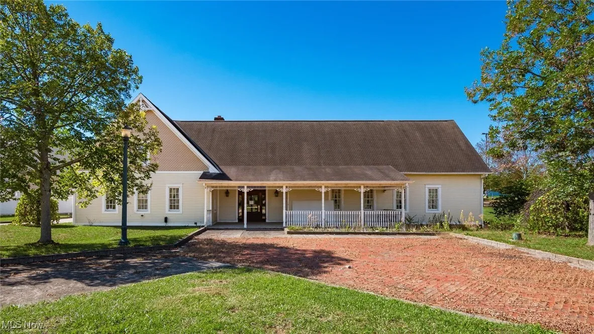 View of front of property with a porch and a front yard