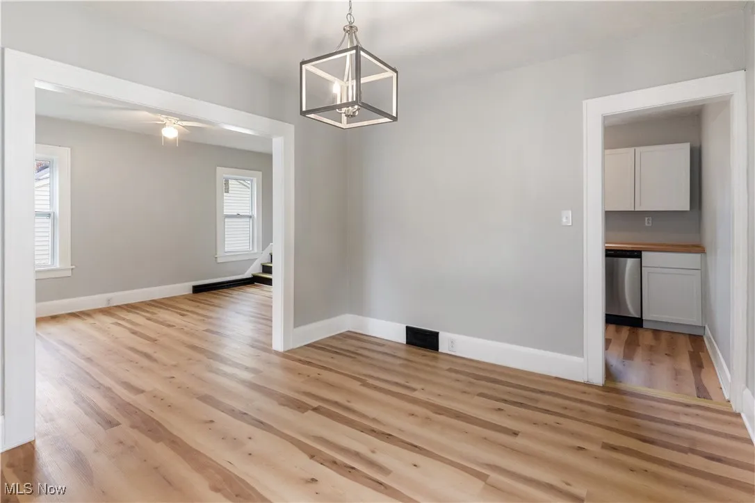 Unfurnished dining area featuring light wood finished floors, a ceiling fan, and a chandelier