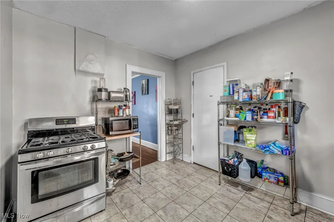 Kitchen featuring appliances with stainless steel finishes, a textured ceiling, and light tile patterned floors
