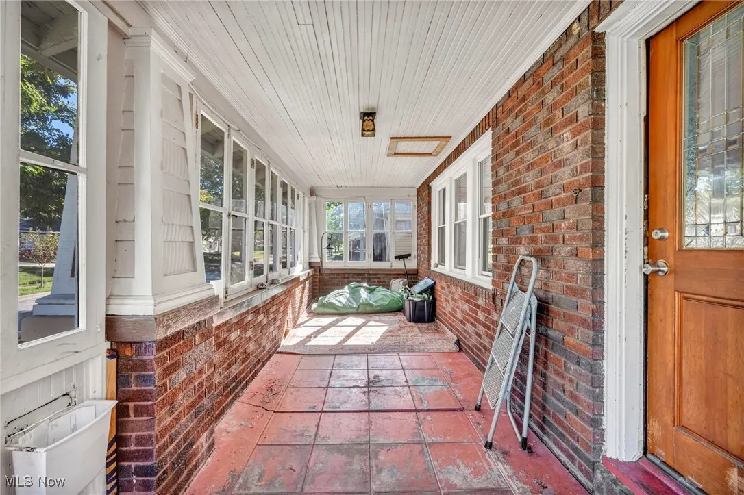 Sunroom with brick wall and wood ceiling