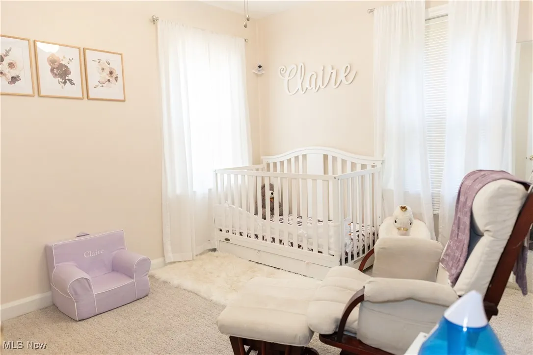 Bedroom featuring a crib and carpet