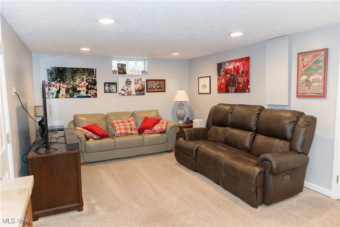 Living area featuring light colored carpet, a textured ceiling, and recessed lighting