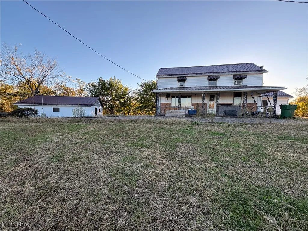 Front of property featuring a metal roof and a lawn