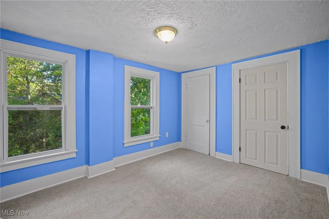 Unfurnished bedroom with a textured ceiling and carpet flooring