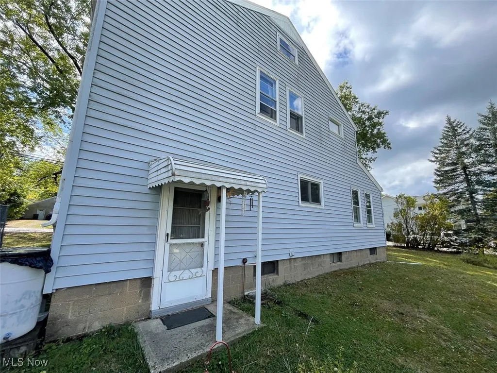 Rear view of property with a lawn
