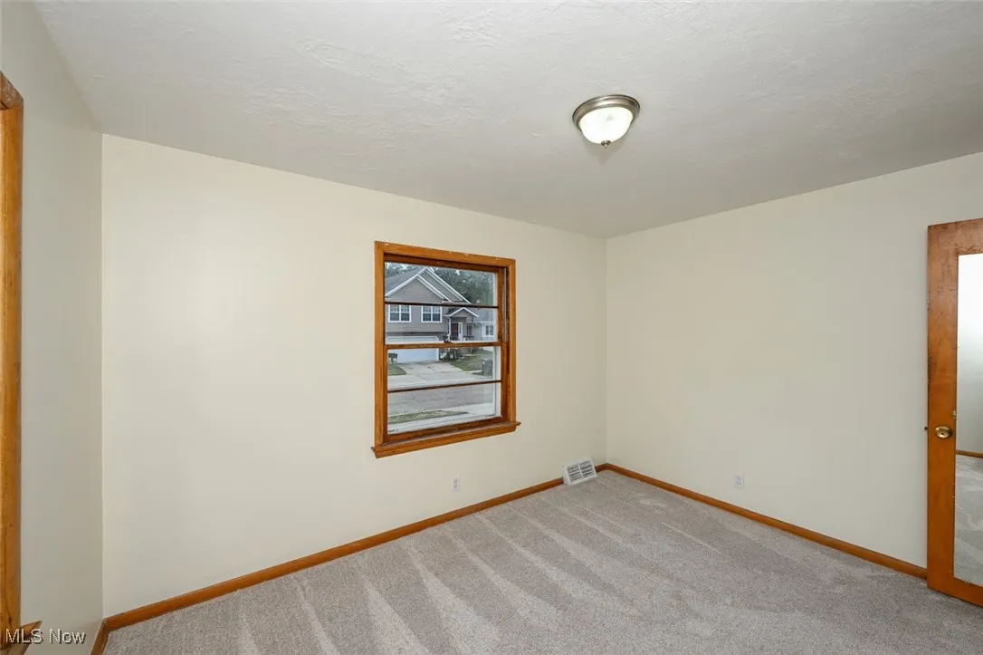 Spare room featuring carpet floors and a textured ceiling
