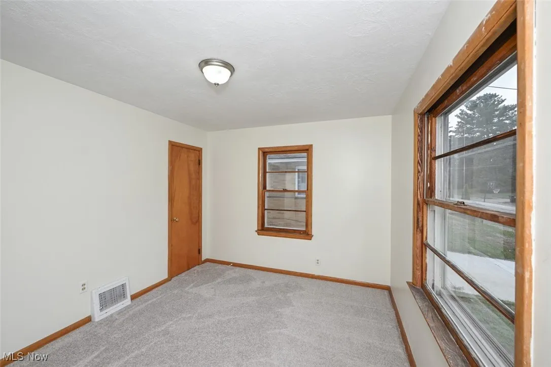 Carpeted empty room with baseboards and a textured ceiling