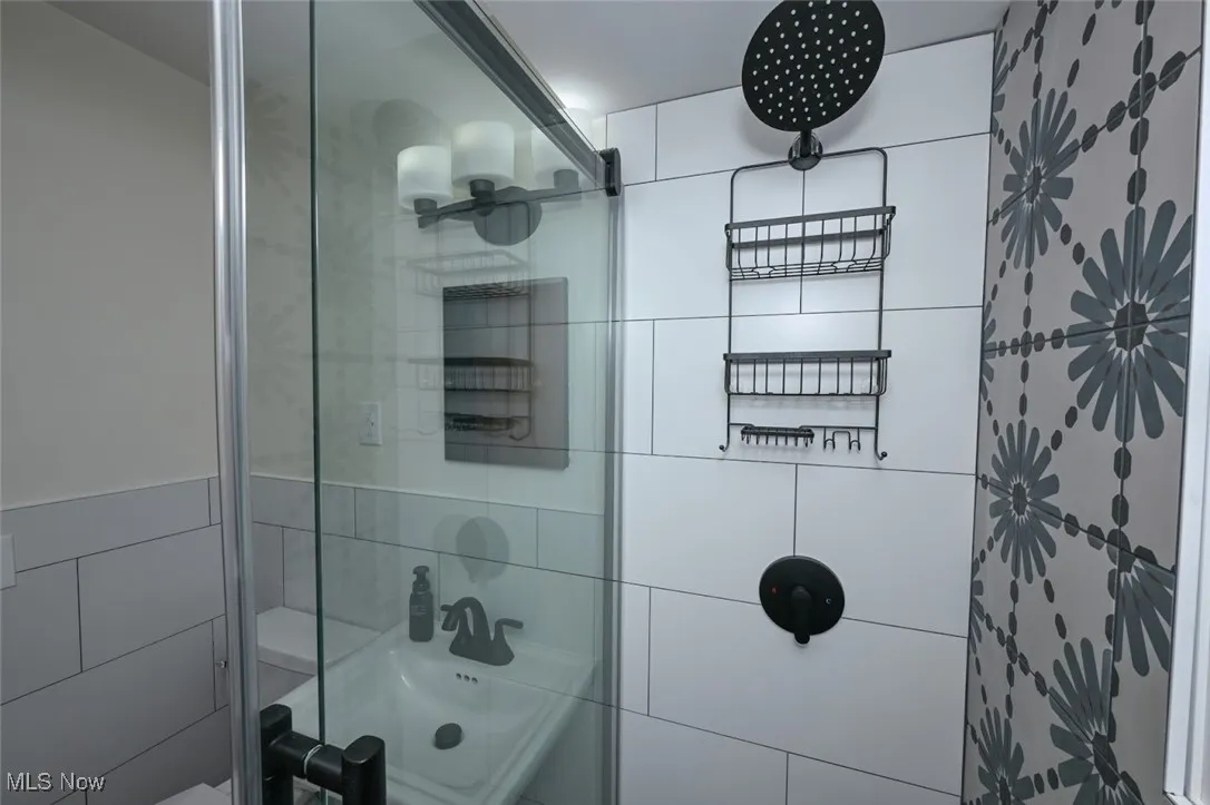 Full bath featuring tiled shower