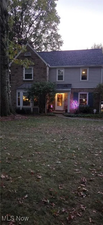 Traditional home featuring a front lawn and a porch